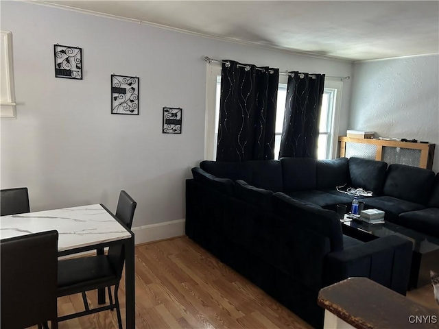 living room featuring crown molding, wood finished floors, and baseboards