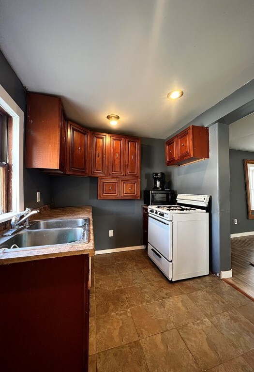 kitchen with white gas range and sink