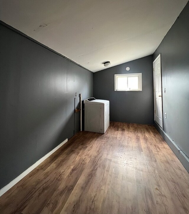 clothes washing area with washer / clothes dryer and wood-type flooring