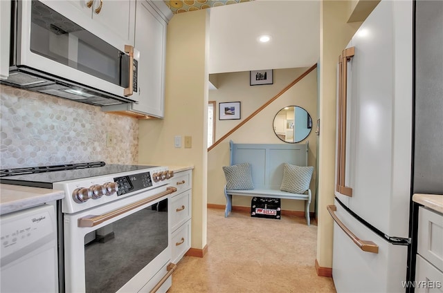 kitchen with tasteful backsplash, white cabinetry, and white appliances