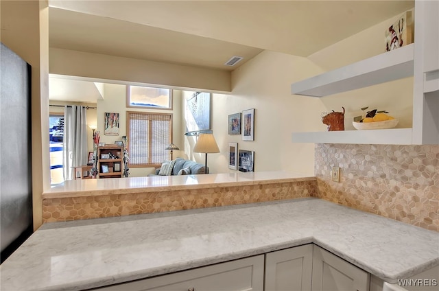 kitchen with decorative backsplash and white cabinets