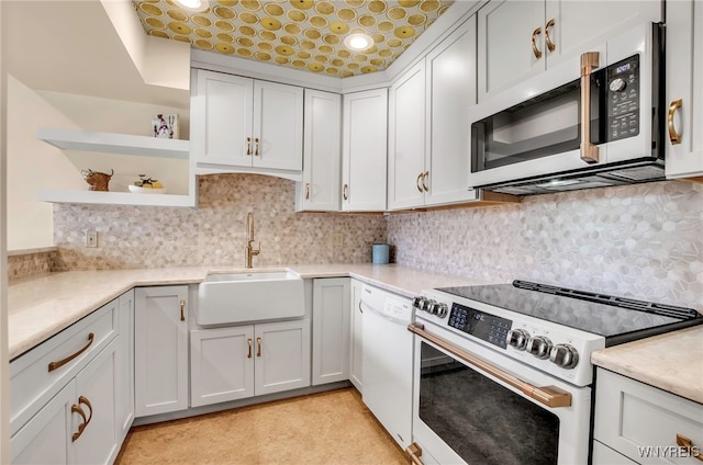 kitchen with tasteful backsplash, sink, white cabinets, and white appliances