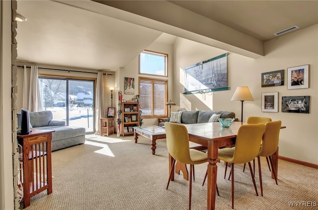 dining space featuring light carpet and plenty of natural light