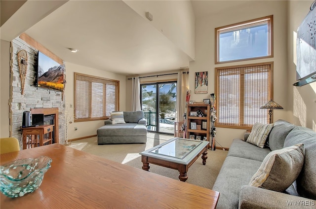 carpeted living room featuring a towering ceiling and a fireplace