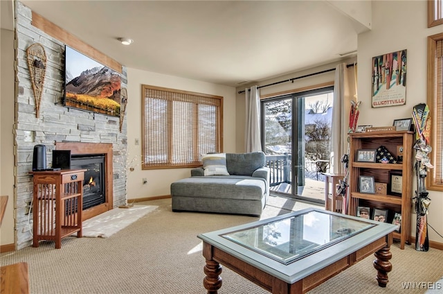 carpeted living room with a stone fireplace