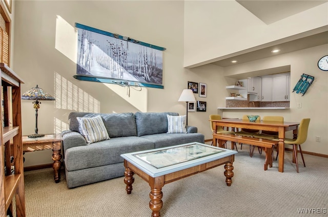 carpeted living room with a high ceiling