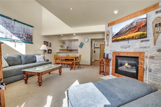 carpeted living room featuring a stone fireplace