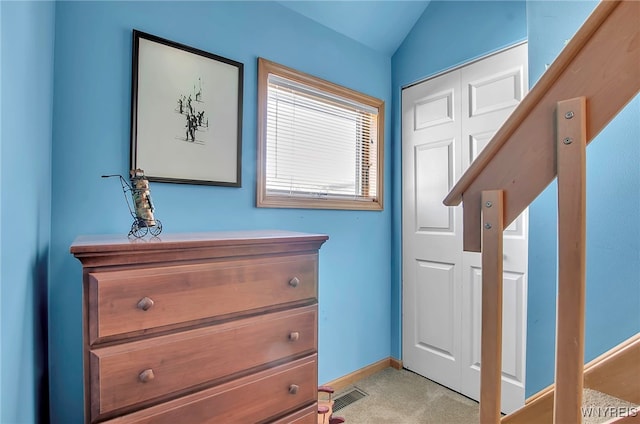 doorway with lofted ceiling and light carpet