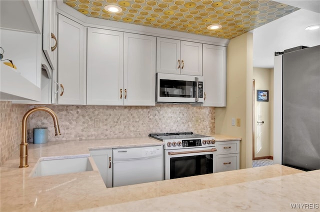 kitchen featuring sink, white cabinets, stainless steel range with electric stovetop, white dishwasher, and light stone countertops