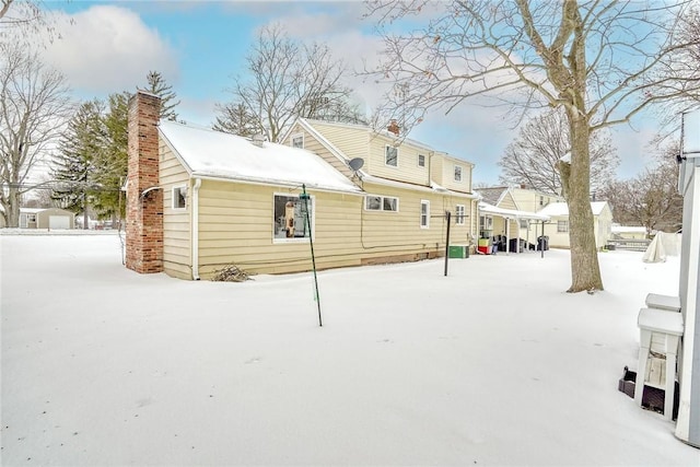 view of snow covered rear of property