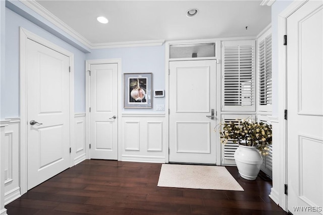 foyer entrance with dark hardwood / wood-style flooring and ornamental molding