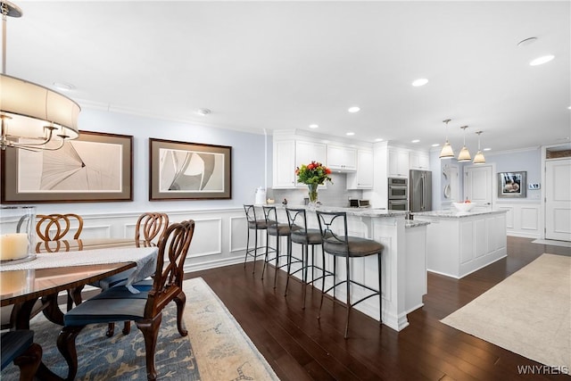 dining space featuring ornamental molding and dark hardwood / wood-style floors