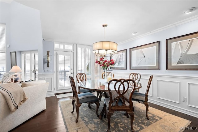 dining space with crown molding and dark wood-type flooring