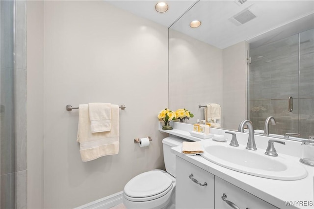 bathroom featuring vanity, a shower with shower door, and toilet