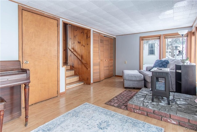 living room with light hardwood / wood-style floors and a wood stove