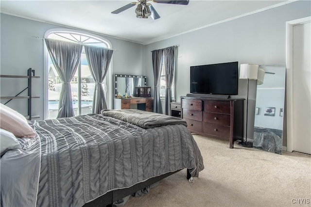 carpeted bedroom with ornamental molding and ceiling fan