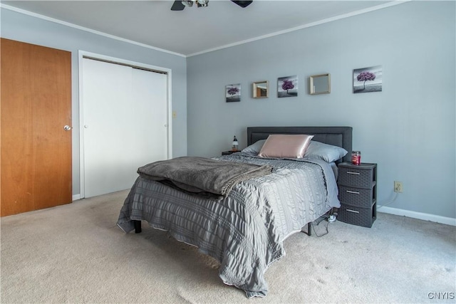 bedroom with ornamental molding, carpet, ceiling fan, and a closet