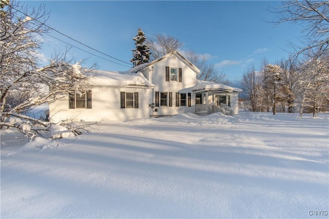 snow covered house featuring covered porch