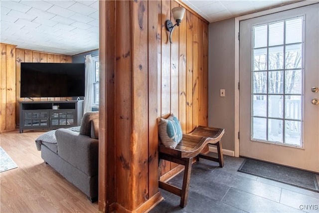 doorway to outside featuring wood-type flooring, a wealth of natural light, and wood walls