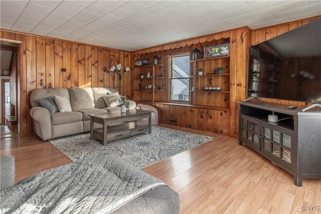 living room featuring wooden walls and light hardwood / wood-style floors