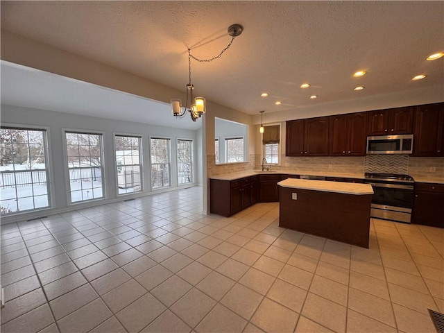 kitchen featuring sink, decorative light fixtures, stainless steel appliances, and decorative backsplash