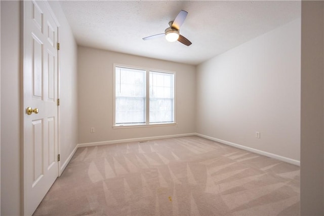 carpeted spare room with a textured ceiling and ceiling fan