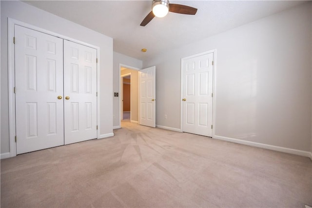 unfurnished bedroom featuring light carpet, ceiling fan, and a closet