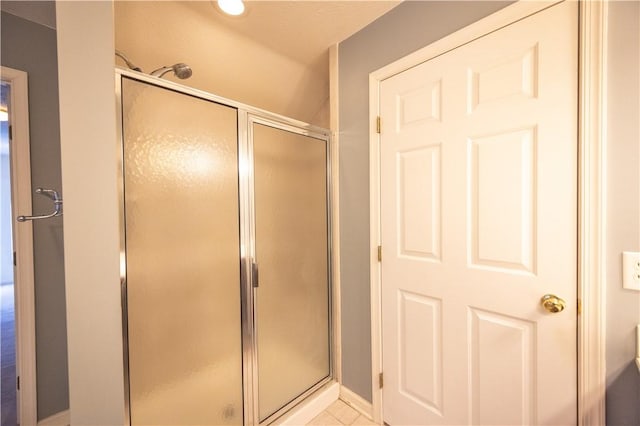 bathroom with an enclosed shower and tile patterned floors