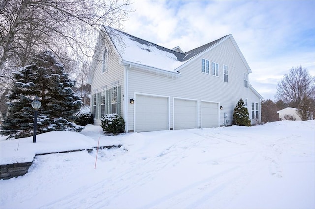 snow covered property featuring a garage