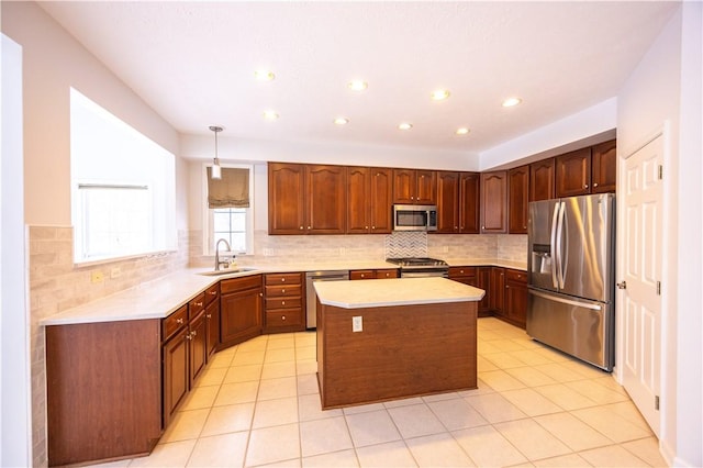 kitchen featuring sink, a center island, hanging light fixtures, appliances with stainless steel finishes, and decorative backsplash