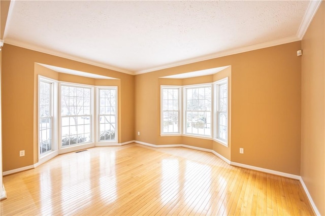 unfurnished room with crown molding, a textured ceiling, and light hardwood / wood-style floors