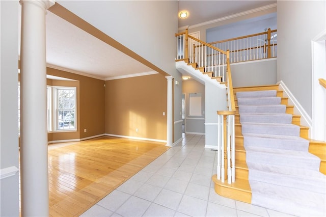 staircase with ornate columns, ornamental molding, and wood-type flooring