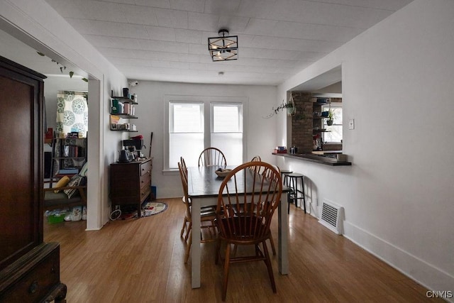 dining space with wood-type flooring