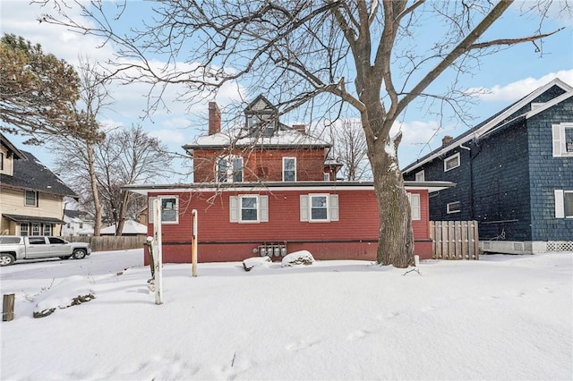 view of snow covered back of property