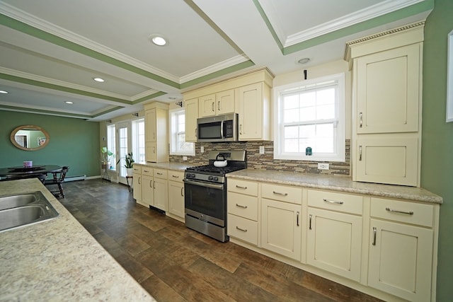 kitchen featuring tasteful backsplash, dark hardwood / wood-style flooring, ornamental molding, stainless steel appliances, and cream cabinetry