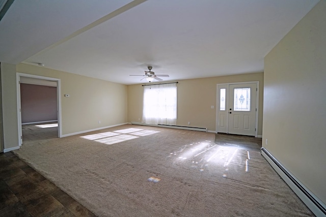 interior space featuring baseboard heating, ceiling fan, and dark carpet