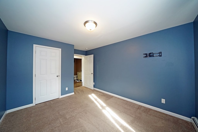 unfurnished bedroom with a baseboard radiator and carpet