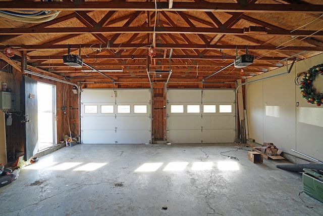 garage with a garage door opener and electric panel