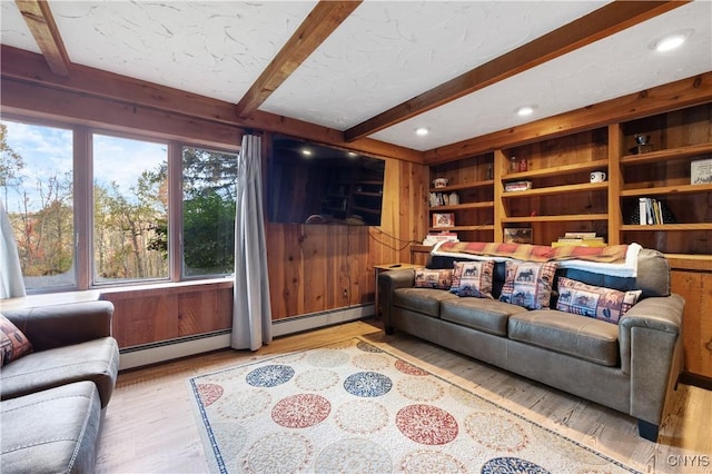 living room featuring wood-type flooring, beam ceiling, wooden walls, and a baseboard radiator