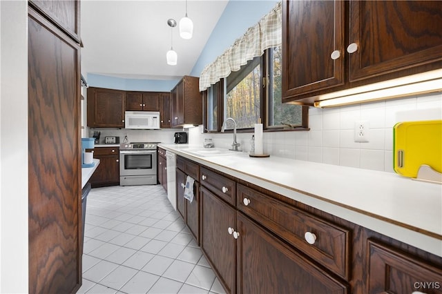 kitchen with lofted ceiling, sink, appliances with stainless steel finishes, dark brown cabinets, and decorative light fixtures