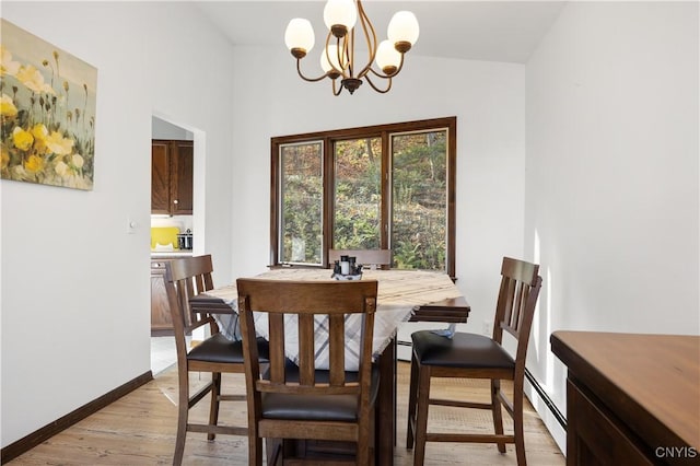 dining space featuring an inviting chandelier, light wood-type flooring, and baseboard heating