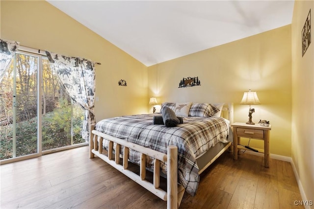 bedroom with hardwood / wood-style flooring, vaulted ceiling, and multiple windows