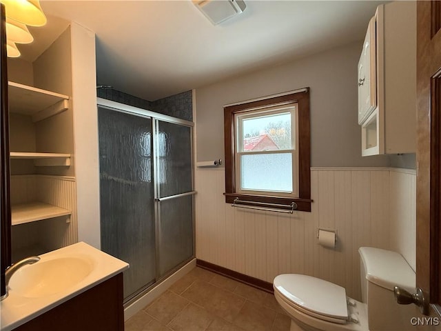 bathroom featuring tile patterned flooring, toilet, vanity, and walk in shower