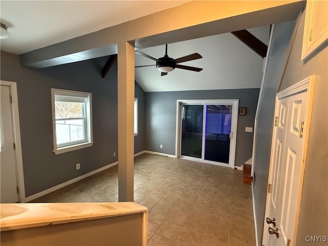 interior space featuring vaulted ceiling with beams, ceiling fan, and light tile patterned flooring