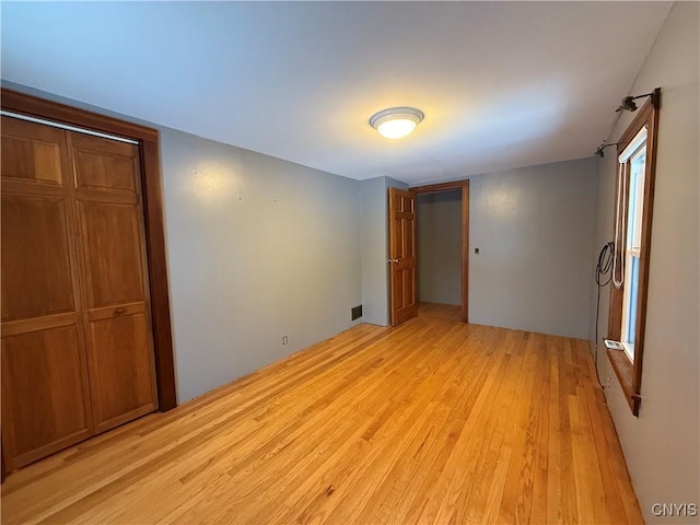 unfurnished bedroom featuring light hardwood / wood-style floors and a closet