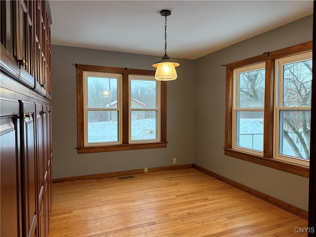 unfurnished dining area with light wood-type flooring