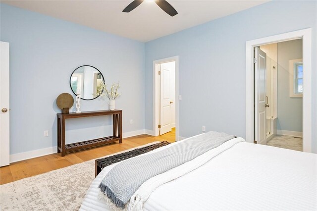 bedroom featuring ceiling fan, ensuite bathroom, and light hardwood / wood-style floors