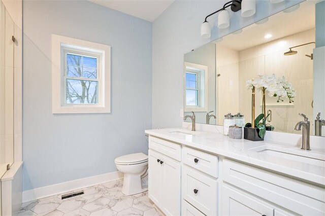 bathroom featuring vanity, toilet, and walk in shower