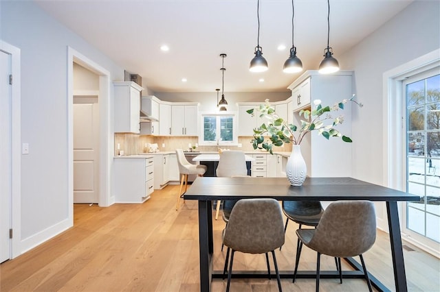 dining room with a wealth of natural light and light wood-type flooring