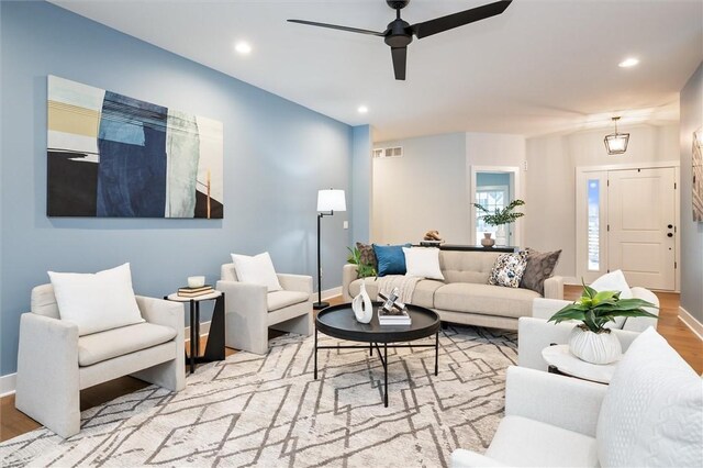 living room featuring ceiling fan and light hardwood / wood-style flooring